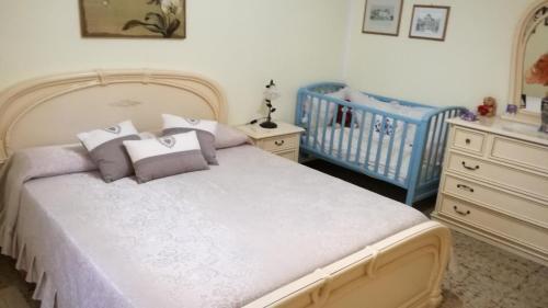 a bedroom with a bed and a crib and a baby crib at Appartamento Mosas in Alghero