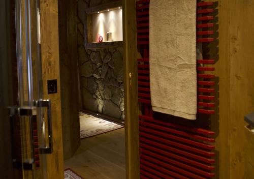 un bagno con un asciugamano rosso appeso a una parete di Haus Martina a Sappada