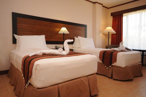 Säng eller sängar i ett rum på Hotel Tropika