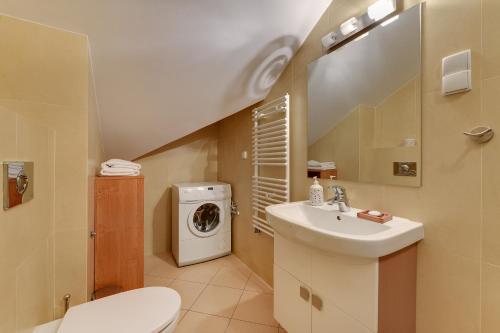 a bathroom with a sink and a washing machine at Apartamenty Apartinfo Jasny Brzeg in Władysławowo