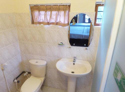 La petite salle de bains est pourvue de toilettes et d'un lavabo. dans l'établissement Riviera Resort, à Batticaloa