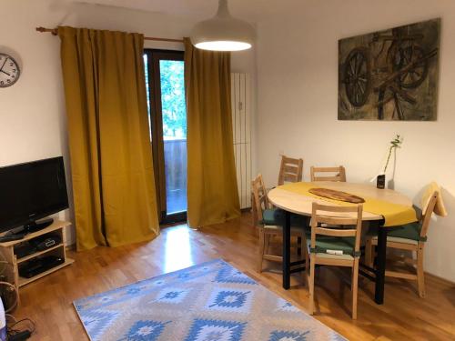 a living room with a table and chairs and a television at STILL Apartament Sinaia in Sinaia