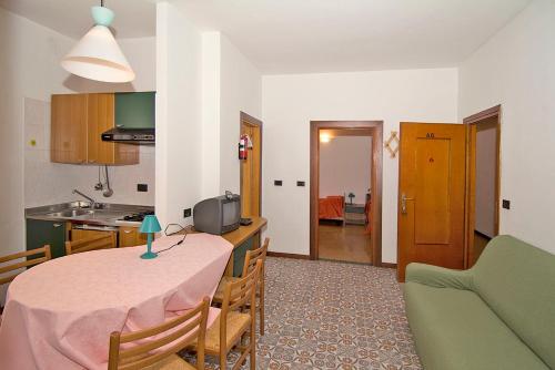 a kitchen and a living room with a table and a couch at Camping Hotel Au Lac De Como in Sorico