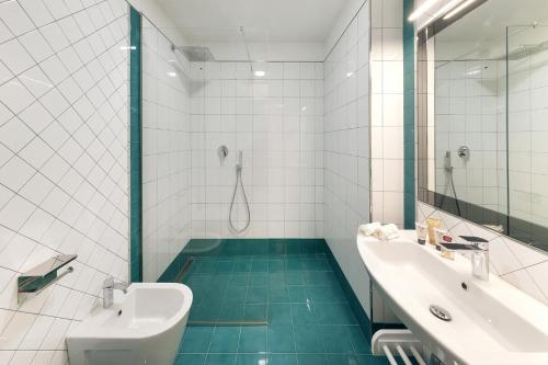 bagno bianco con lavandino e doccia di AMORE RENTALS - Villa Giove a Nerano