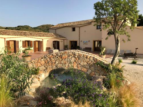 a stone bridge over a pond in front of a house at Agriturismo Antichi Granai in Calatafimi