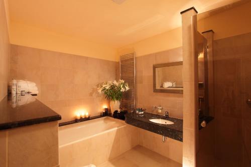 ein Badezimmer mit einer Badewanne und einem Waschbecken in der Unterkunft Elysee Hotel in Prag
