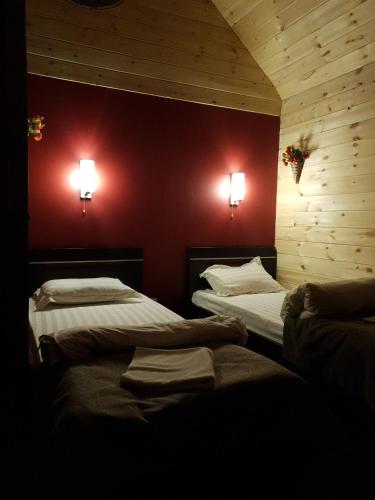 フジュルにあるГостиница Olkhonのベッド2台 壁に照明2つが備わる客室です。
