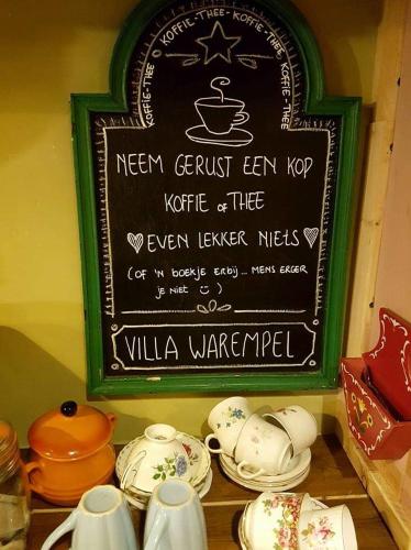 a chalkboard with a sign on a shelf with dishes at Villa Warempel in Valkenburg