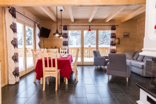 a dining room with a red table and chairs at TatryTop Osada Luxury Chalets Kościelisko in Kościelisko