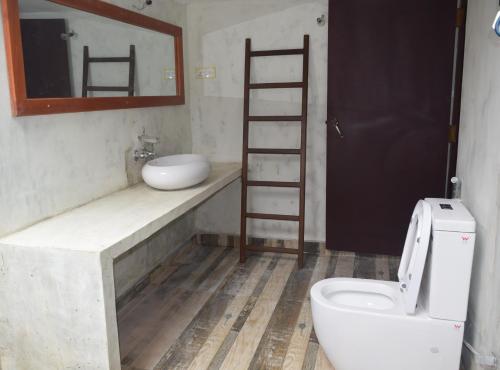 a bathroom with a toilet and a sink and a mirror at Muthu Nila villa- Mirissa in Mirissa