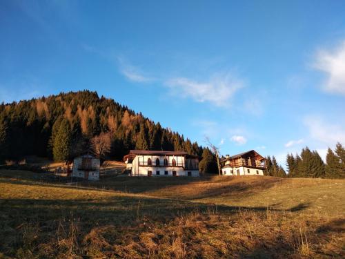 a house on top of a hill with a mountain at Hotel Serenella in Canale San Bovo