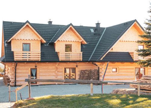 a log house with a black roof at Dwór Pan Tadeusz in Orawka