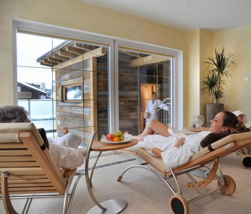 two people laying in chairs in a room at Hotel Sonnschupfer in Schladming