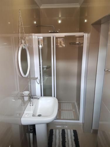 a white bathroom with a shower and a sink at Estee House in Newcastle