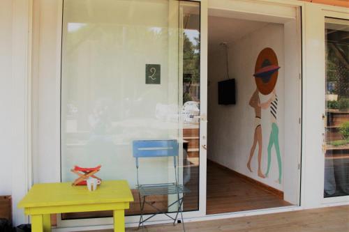 een glazen schuifdeur met een schilderij van een vrouw aan de muur bij Hotel L'Escale in Porto Pollo