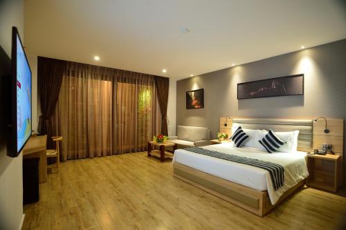 een hotelkamer met een bed en een flatscreen-tv bij Aiden Saigon Hotel in Ho Chi Minh-stad