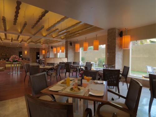 jadalnia ze stołami i krzesłami w restauracji w obiekcie The Quorum w mieście Mysuru