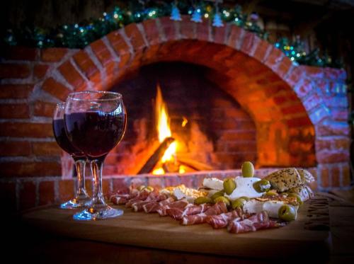 a glass of red wine next to a brick fireplace at Rtanjski konak in Boljevac