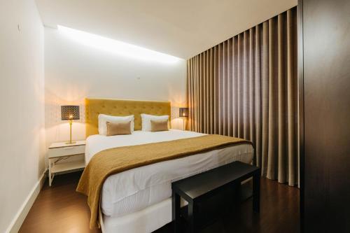 リスボンにあるLisbon Avenue Marquês - Luxury Apartの大きなベッドとテーブルが備わるホテルルームです。