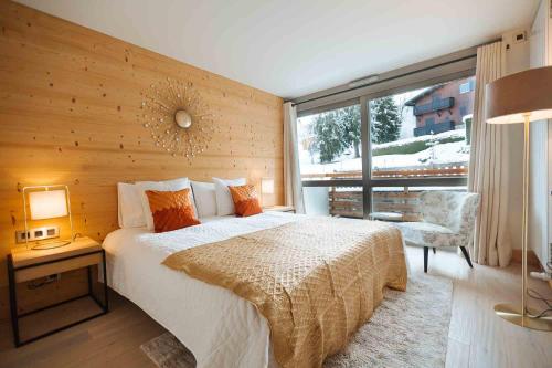 a bedroom with a large bed and a large window at Megeve Appartment – Vacances d'hiver – АЕ102 in Megève