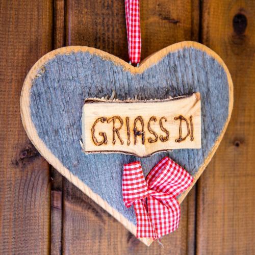 a wooden heart hanging on a wooden wall with a bow tie at Ferienhütte Puutz in Wörgl