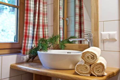 ein Waschbecken im Bad mit Handtüchern auf einer Holztheke in der Unterkunft Rainbachhütte-Waldgut Granig in Glödnitz