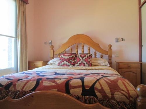 a bed with a wooden headboard in a bedroom at La Casa de Liber in Tandil