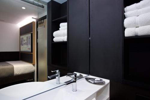 Un baño con lavabo, espejo y toallas. en The Z Hotel Covent Garden, en Londres
