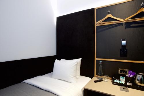 a bedroom with a bed and a table with a phone at The Z Hotel Covent Garden in London