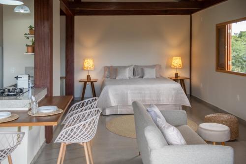 a bedroom with a bed and a table and chairs at Casas Gengibre in Alto Paraíso de Goiás