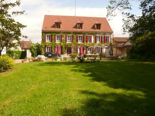 a large house with a large lawn in front of it at Chambres d'hôtes et Roulotte Au Bonheur Du Parc in Le Breuil