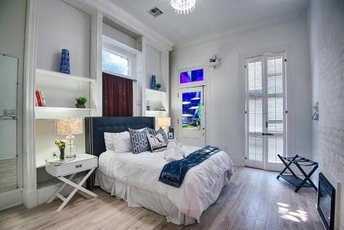 a bedroom with a bed and a desk and windows at 7 Bedroom - Sleeps 14! Next to Bourbon Street in New Orleans