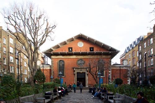 a brick building with people sitting on benches in front of it at The Z Hotel Covent Garden in London