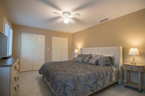 a bedroom with a bed and a ceiling fan at Chic Private Pool Home Minutes to Bonita Beaches in Bonita Springs