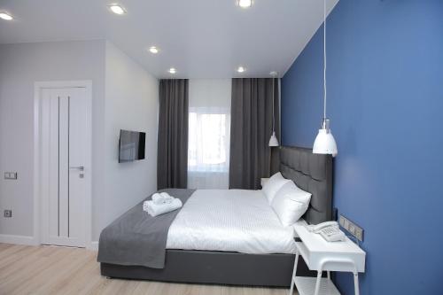 a bedroom with a large bed with a blue wall at Hotel Sova in Krasnoyarsk