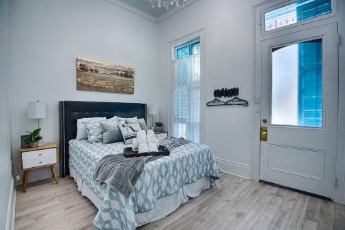 a white bedroom with a bed and a door at Five BR - Sleeps 10! Steps from French Quarter in New Orleans