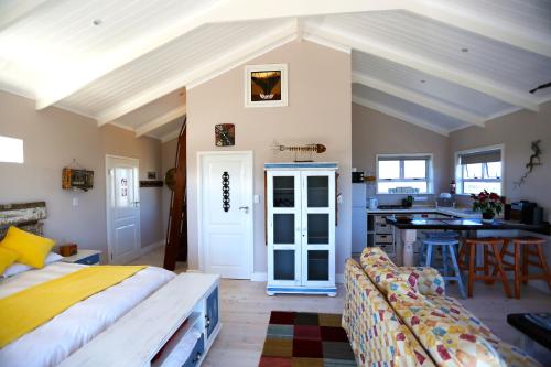 a bedroom with a bed and a kitchen at Reddoor Studio in Pringle Bay