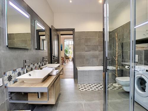 une salle de bain avec deux lavabos et une machine à laver dans l'établissement Nestor&Jeeves - PALAIS MARIE PRESTIGE - Central - Close sea, à Nice