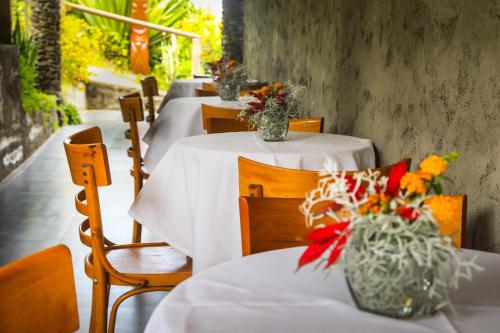 a row of tables with white tablecloths and flowers on them at Easter Island Ecolodge in Hanga Roa