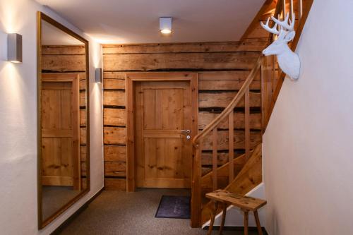 a room with wooden walls and a staircase with a mirror at Chalet "Altes Schulhaus" in Schruns-Tschagguns