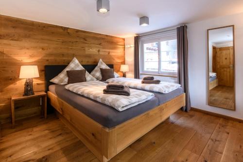 a bedroom with a large bed with a wooden wall at Chalet "Altes Schulhaus" in Schruns-Tschagguns