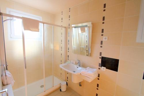 une salle de bain avec un lavabo et une douche dans l'établissement Logis Hotel Restaurant Le Grand Turc, à LʼOie