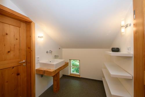 a bathroom with a sink and a wooden door at Chalet "Altes Schulhaus" in Schruns