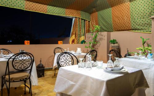 a restaurant with two tables and chairs with white tablecloths at Riad Leila Marrakech in Marrakech