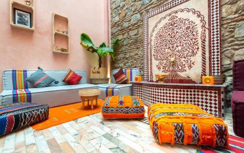 a living room with a blue couch and colorful pillows at Riad Leila Marrakech in Marrakech