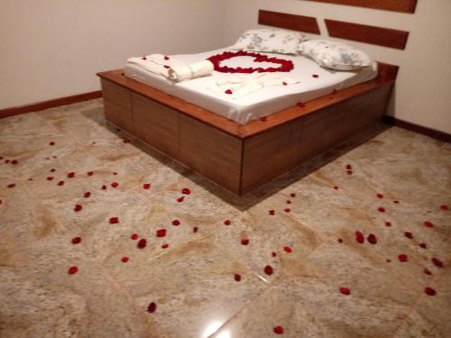 a bedroom with a bed with red flowers on the floor at Rancho das Montanhas in Muniz Freire