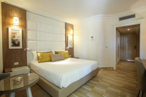 a bedroom with a large bed and a table at Sentido Bellevue Park in Port El Kantaoui