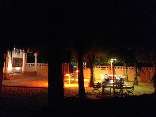 a group of tables and chairs in a courtyard at night at Ramaya Auberge Espagnole in Grand-Popo
