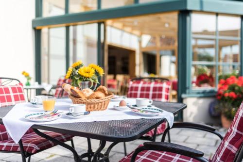 Hotel Stegner في Rödelsee: طاولة عليها سلة من الخبز والزهور