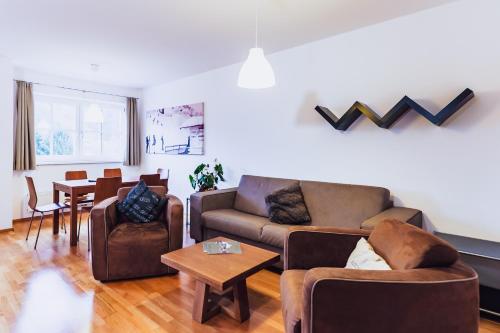 a living room with two couches and a table at Alpine Resort by Alpin Rentals in Kaprun